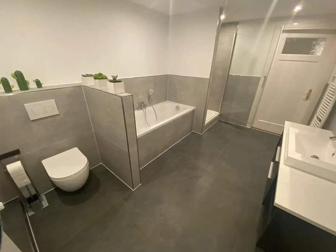 Badezimmer Sanierung München Modernes Badezimmer mit grauen Fliesen und Badewanne in München