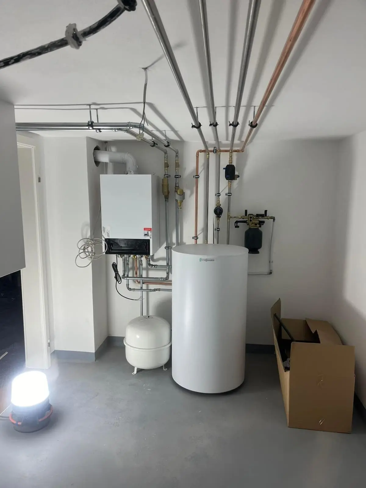 Heizungs- und Wassertankinstallation München Installierte Heizung und Wassertank in einem Keller nach erfolgreicher Installation in München