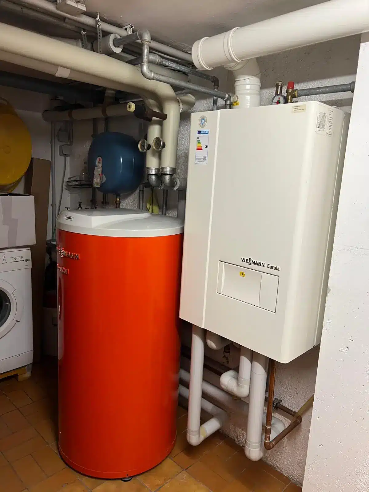 Effiziente Heizungsanlage München Installierte Heizkessel- und Warmwasserspeicheranlage im Keller eines Hauses in München