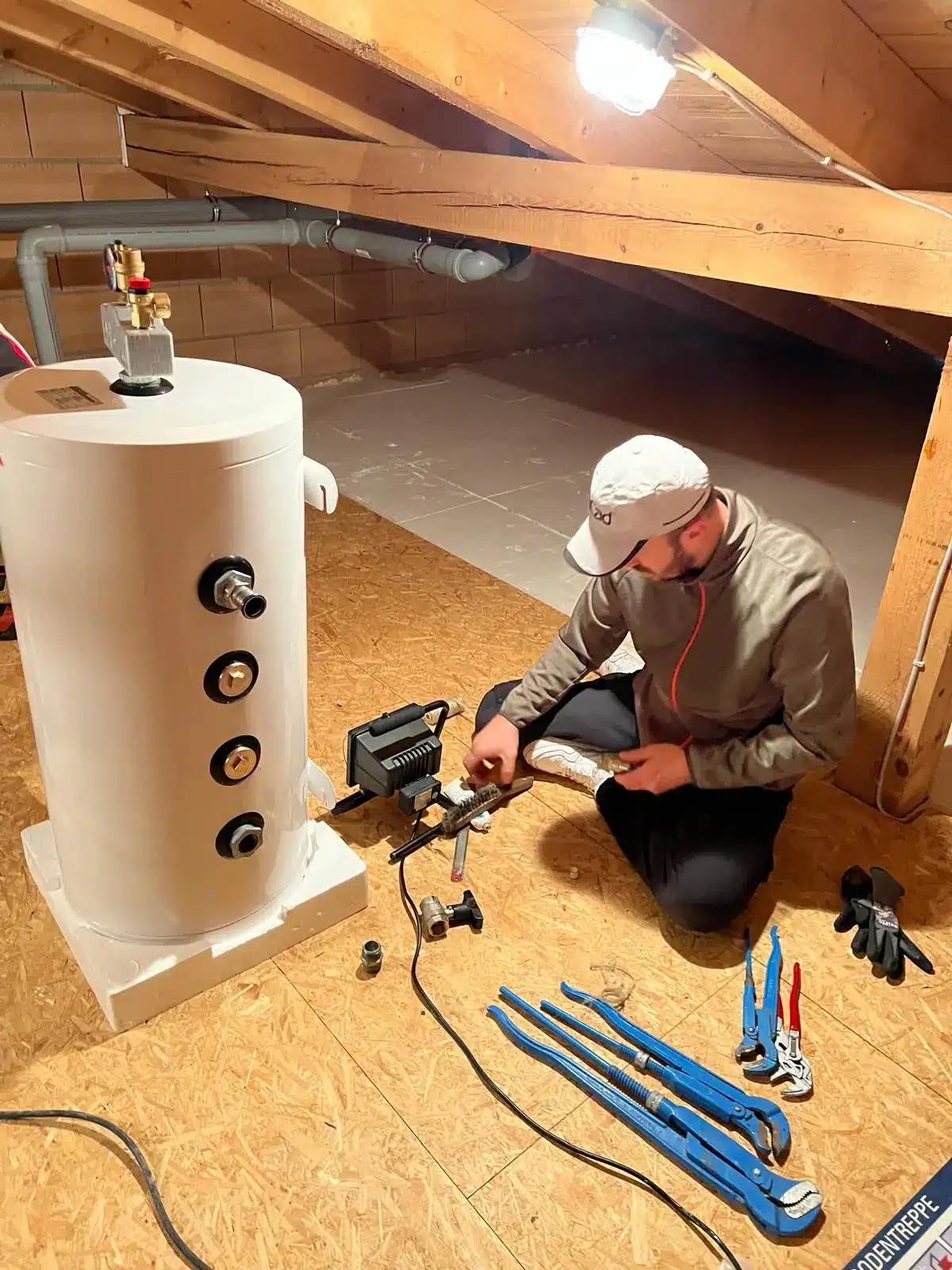 Wassertankinstallation Dachboden München Techniker bei der Installation eines Wassertanks in einem Dachboden