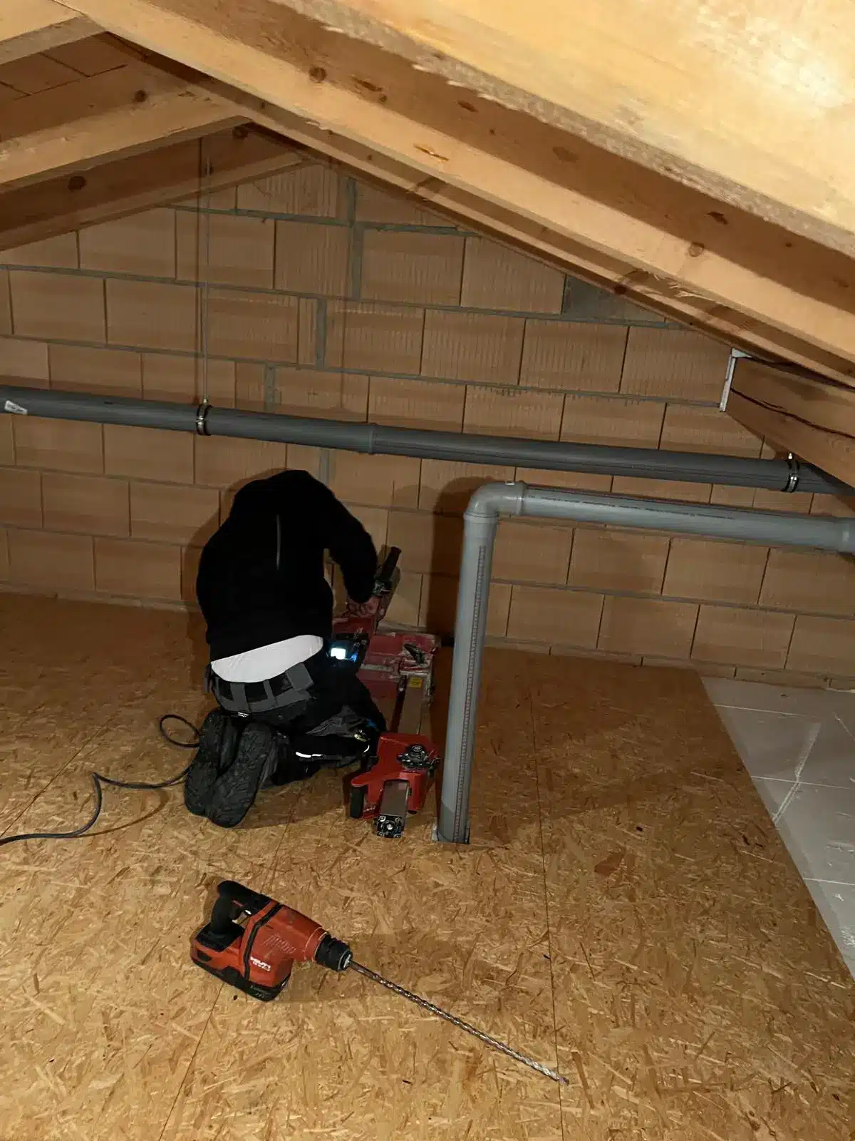 Heizungsinstallation im Dachboden München Techniker bei der Installation einer Heizung in einem Dachboden in München